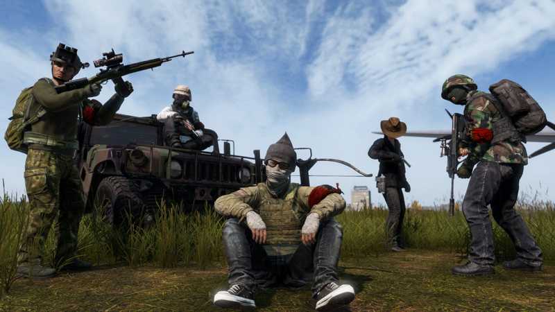 A group of DayZ survivors in camouflage resting by an armored truck in a field